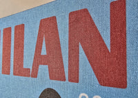 Text 'MILAN' printed on a blue background