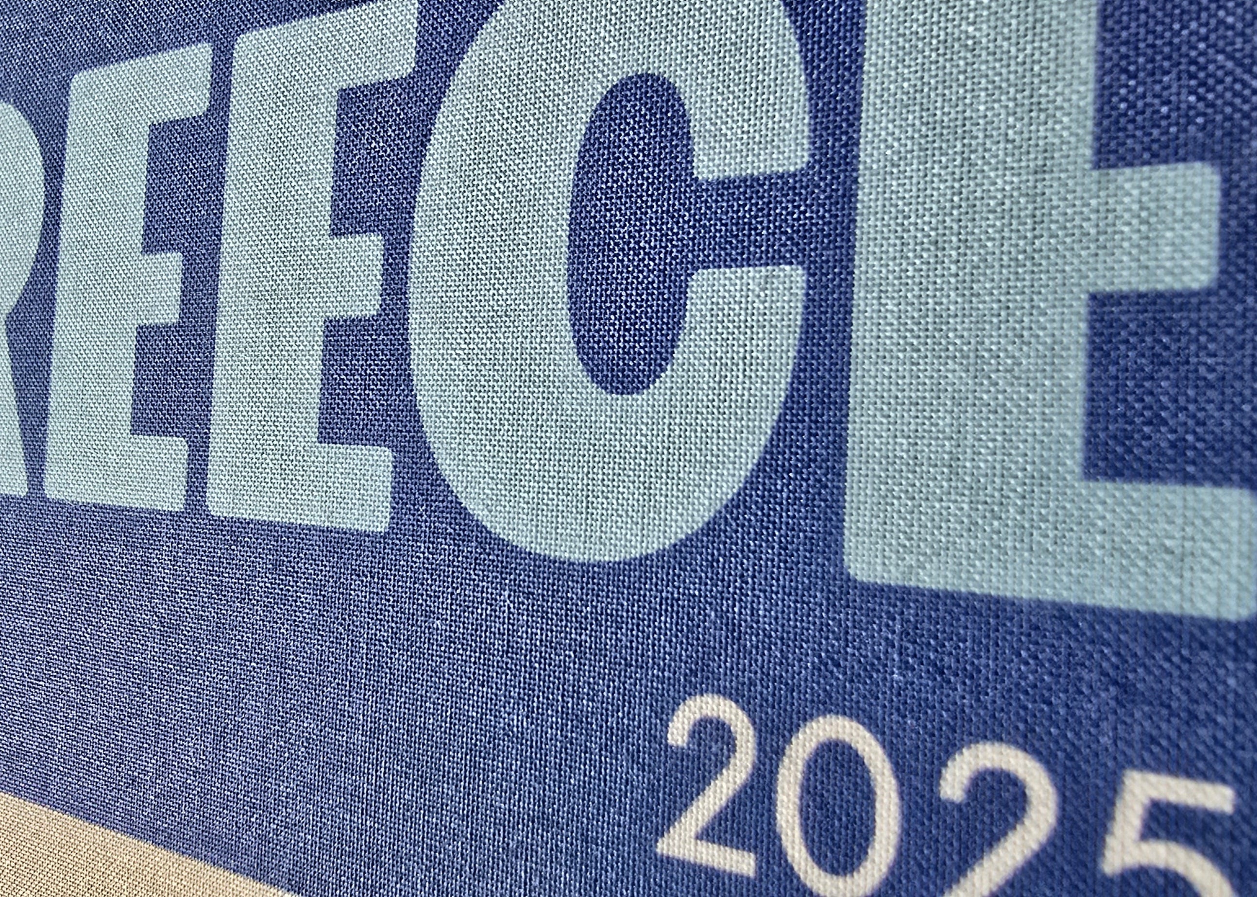 Blue sign with 'GREECE 2025' text on a textured surface