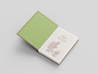 Open book with green cover and white pages on a light gray background