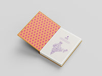 Book with a pink polka dot cover on a gray background
