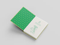 Open book with green and white cover on a gray background
