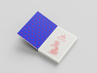 Book with blue cover featuring red polka dots and white pages with red text on a gray background