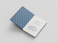 Open book with blue geometric patterned cover on a light gray background