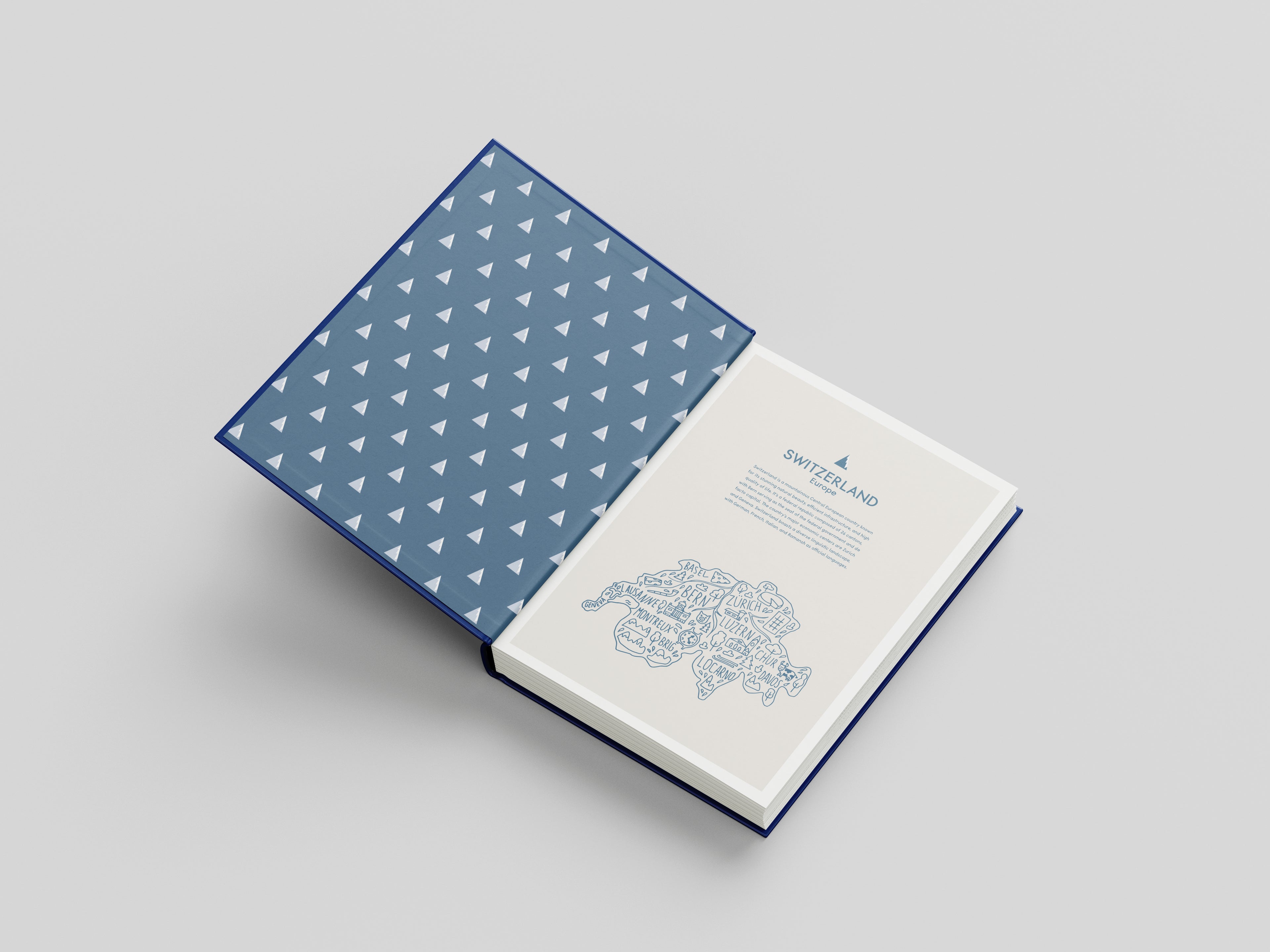 Open book with blue geometric patterned cover on a light gray background
