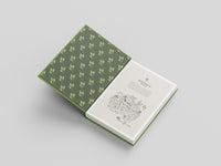 Open book with green leaf patterned cover on a light gray background